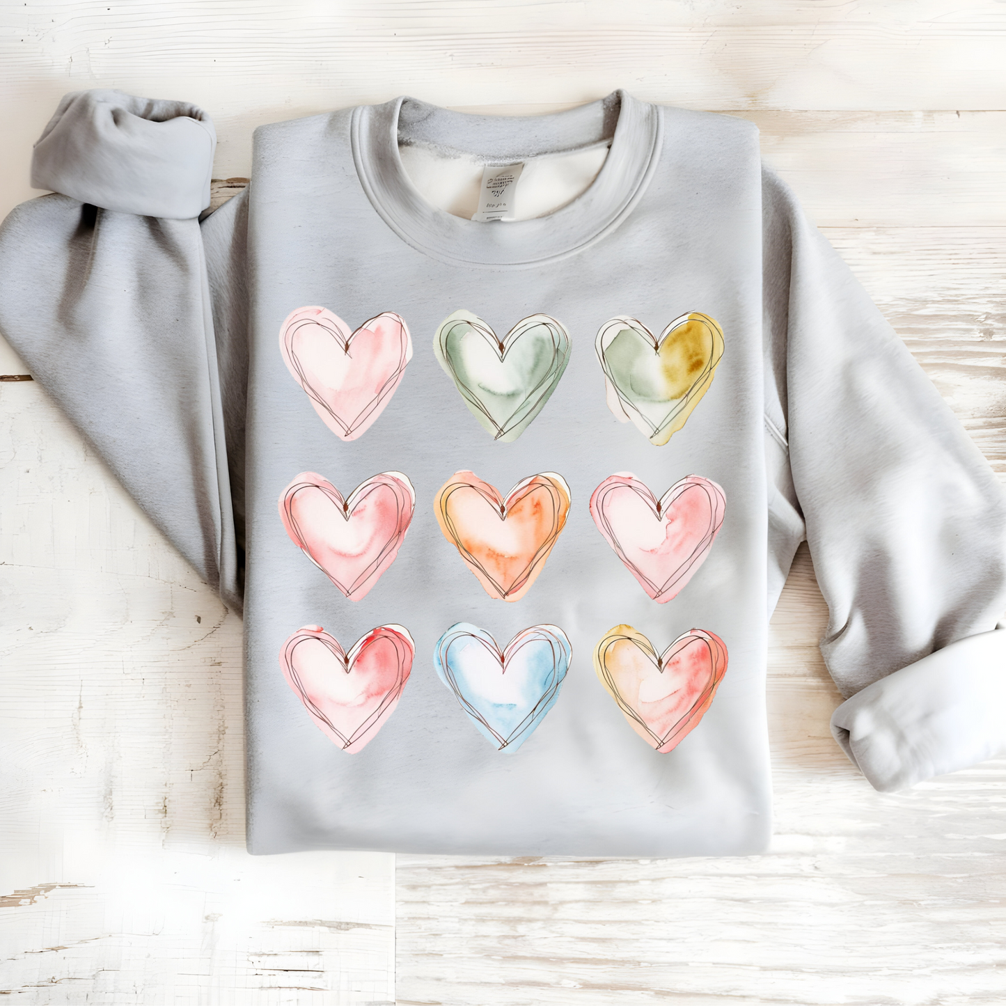 Soft cotton-poly blend sweatshirt featuring nine dreamy watercolor hearts.