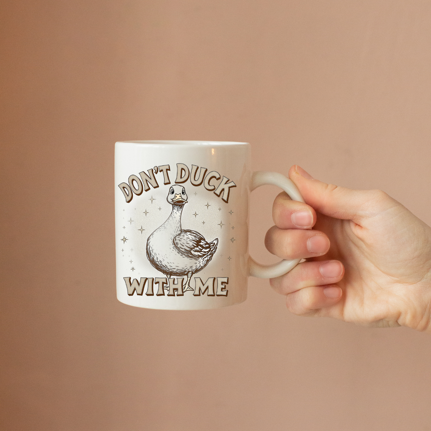 Lifestyle shot of the 'Don’t Duck With Me' sarcastic coffee mug being held with a hot beverage.