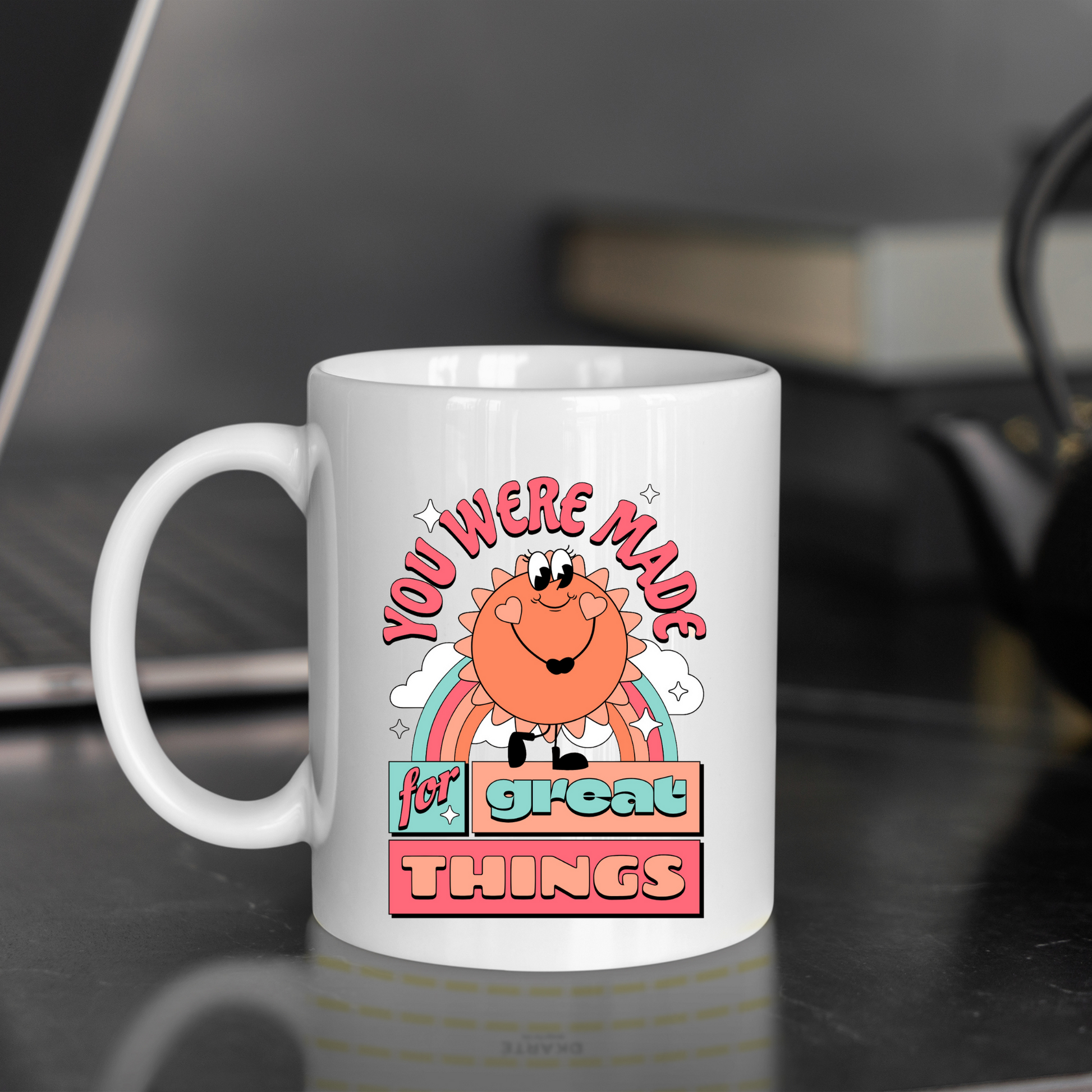 White ceramic mug with a retro "You Were Made for Great Things" design, featuring a sun and rainbow.